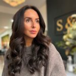 Lady with long dark hair Extensions, service by stylist at Sharp & Owen hair salon